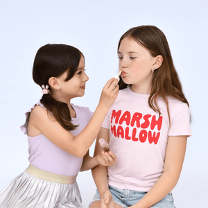 One girl putting chocolate flavoured lip gloss on her friend