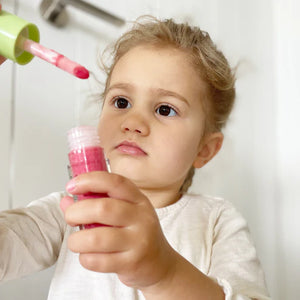 little girl playing with kids natural lip gloss